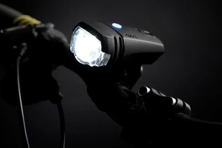 دوچرخه‌سوار با چراغ جلو و عقب روشن در تاریکی