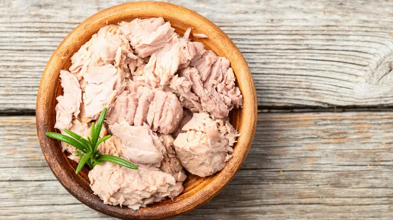 کنسروهای تن ماهی در قفسههای سوپرمارکت با برچسبهای مختلف و رنگهای متنوع