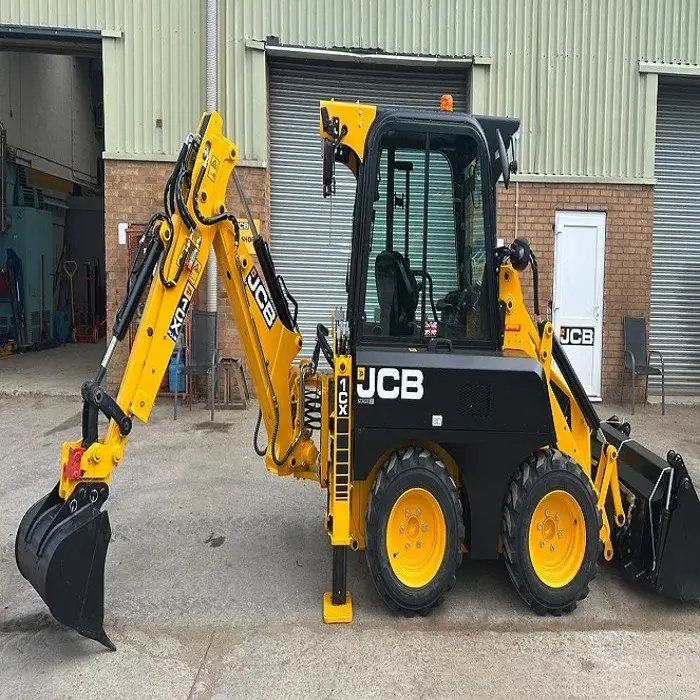 اپراتور در حال استفاده از مینی بکهو لودر JCB 1CX برای عملیات حفر در پروژه ساختوساز