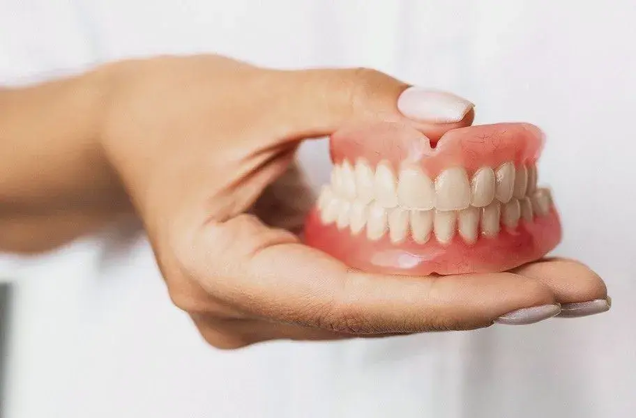 دندانپزشک در حال بررسی و تنظیم قندان برای یک بیمار