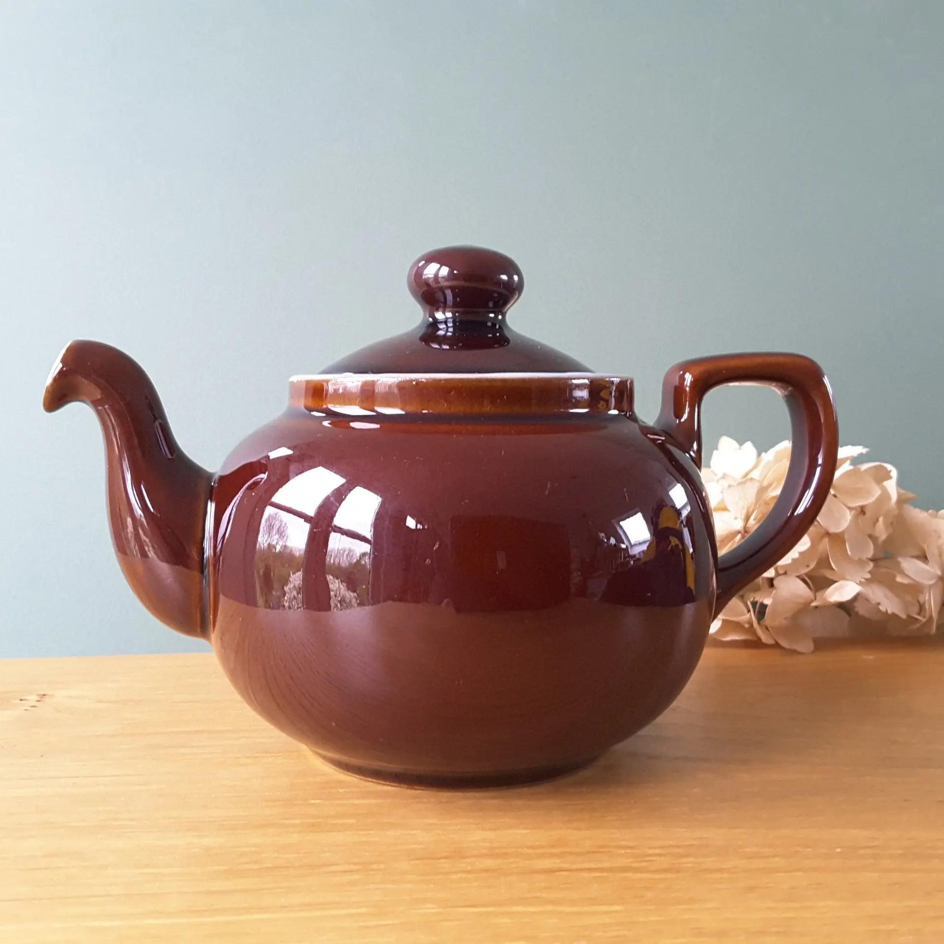 چای دم کرده در قوری سنتی با برگ‌های تازه