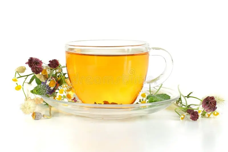 دمنوش گیاهی در فنجان شیشه‌ای با برگ‌های تازه و گلبرگ