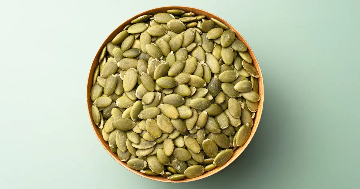 مغز تخمه کدو پوستدار و پوستزدایی شده در کنار یکدیگر