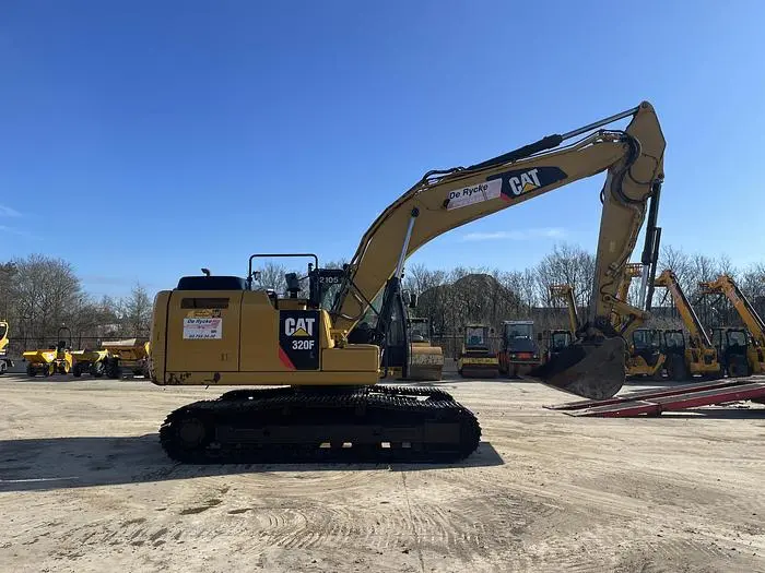 بولدوزر کاترپیلار ۳۲۰ در یک کارگاه تعمیرات با قطعات قابل مشاهده