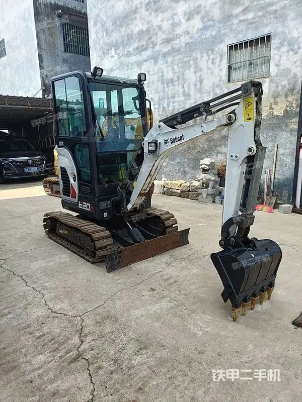 اپراتور در حال کنترل مینی بیل بابکت E20 در یک پروژه عمرانی