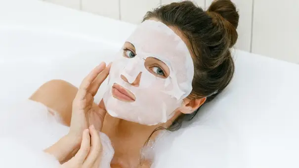 زن با ماسک صورت کاغذی برای پاکسازی و رطوبتدهی پوست