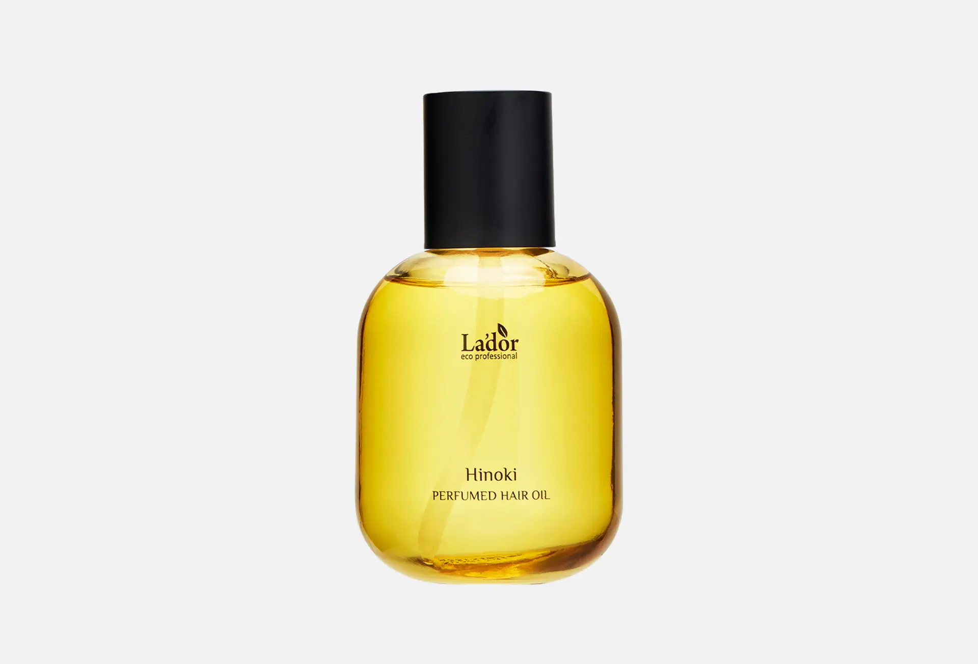 روغن آرگان در یک ظرف شیشه‌ای با قطره‌های روغن در اطراف آن