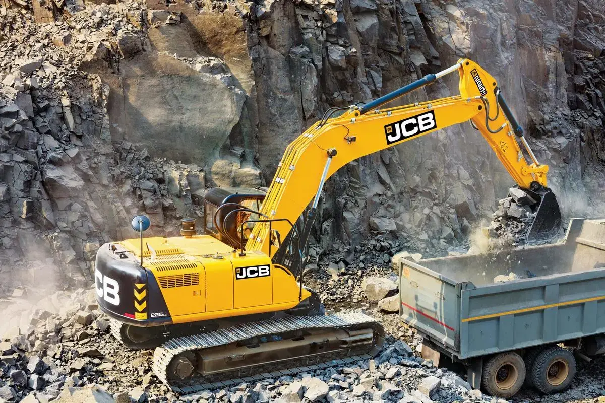 اپراتور بیل مکانیکی JCB در حال کنترل دستگاه در یک محیط صنعتی