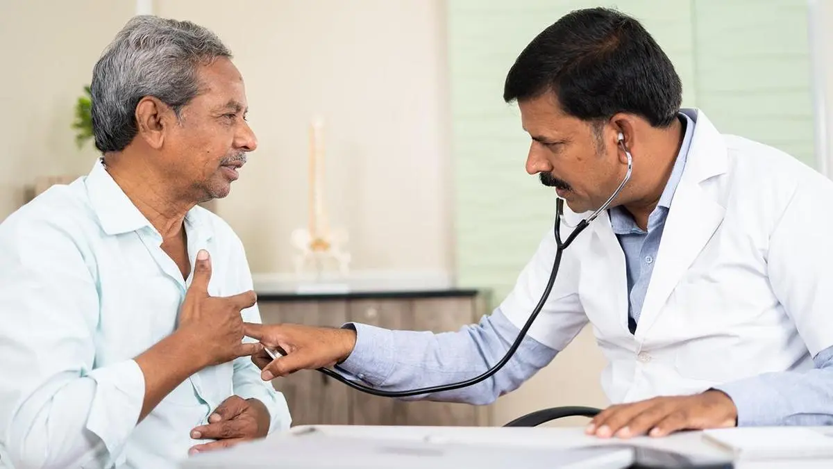 یک پزشک در حال بررسی نتایج آزمایشات یک بیمار برای تشخیص زودهنگام بیماریها
