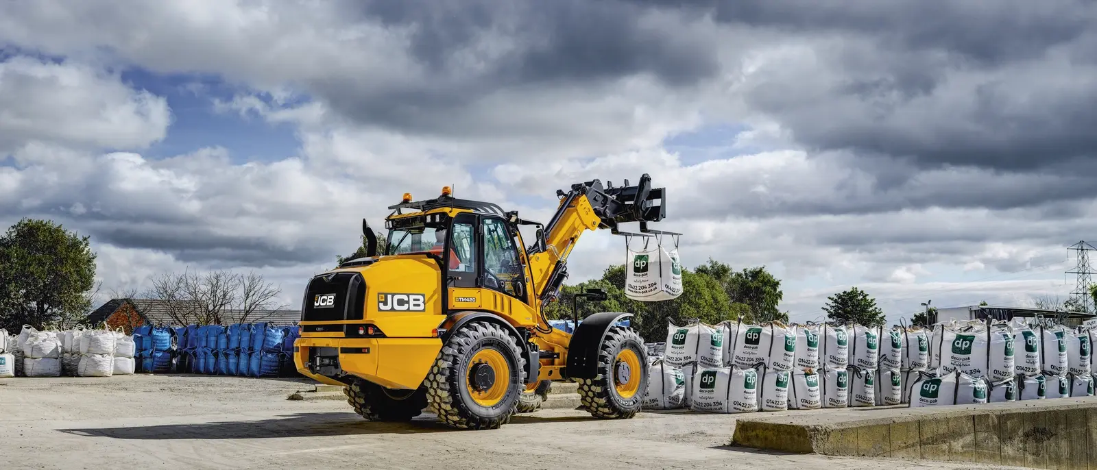 لودر JCB 420 در حال بارگیری مواد در یک پروژه ساختمانی